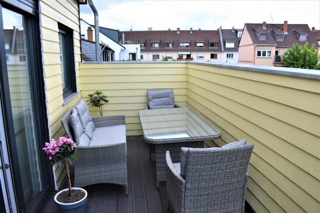 eine Terrasse mit 2 Stühlen und einem Tisch auf dem Balkon in der Unterkunft Heiligenbergblick in Heidelberg