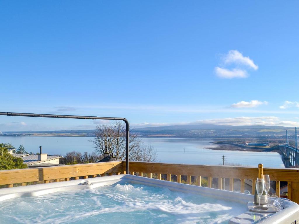 bañera de hidromasaje en el balcón con vistas al agua en Balnacraig, en North Kessock