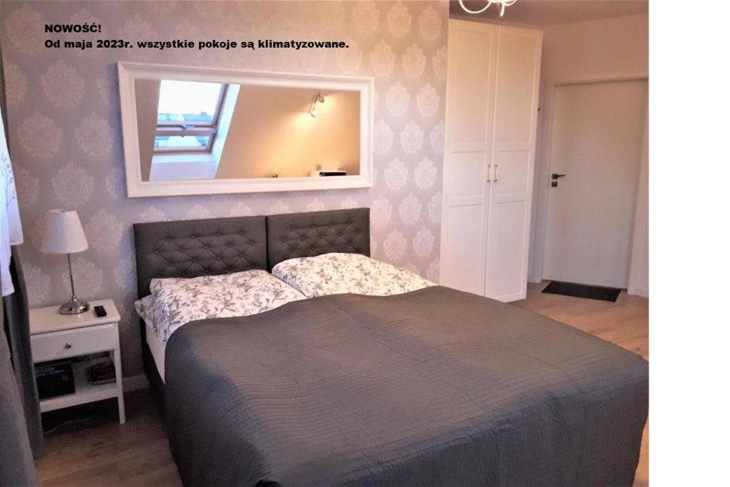 グダニスクにあるPietrzak Apartmentsのベッドルーム1室(ベッド1台、壁掛け鏡付)