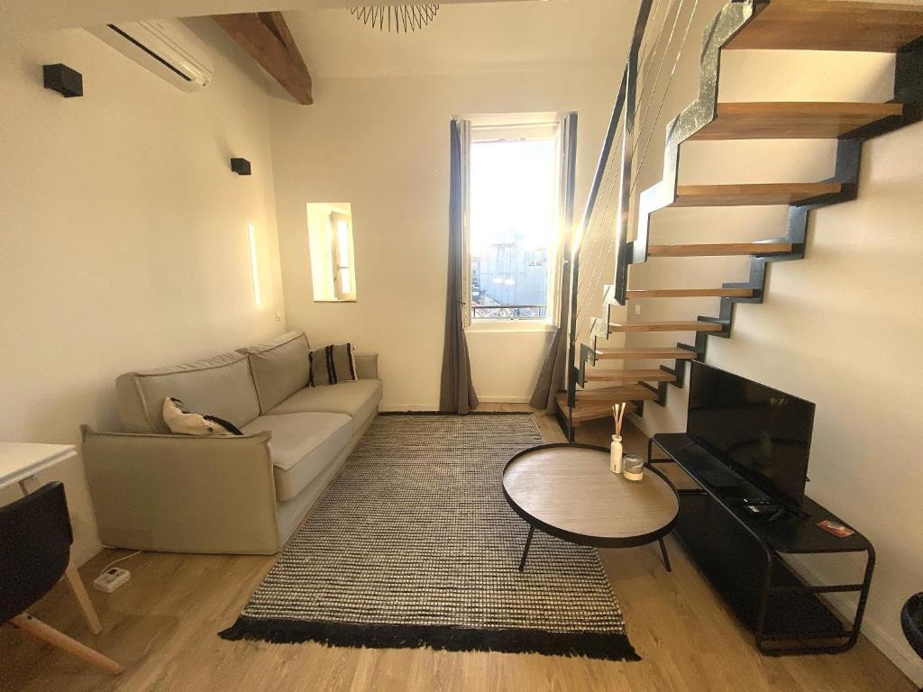 un salon avec un canapé et un escalier dans l'établissement Lamartine hypercentre 503, à Nice