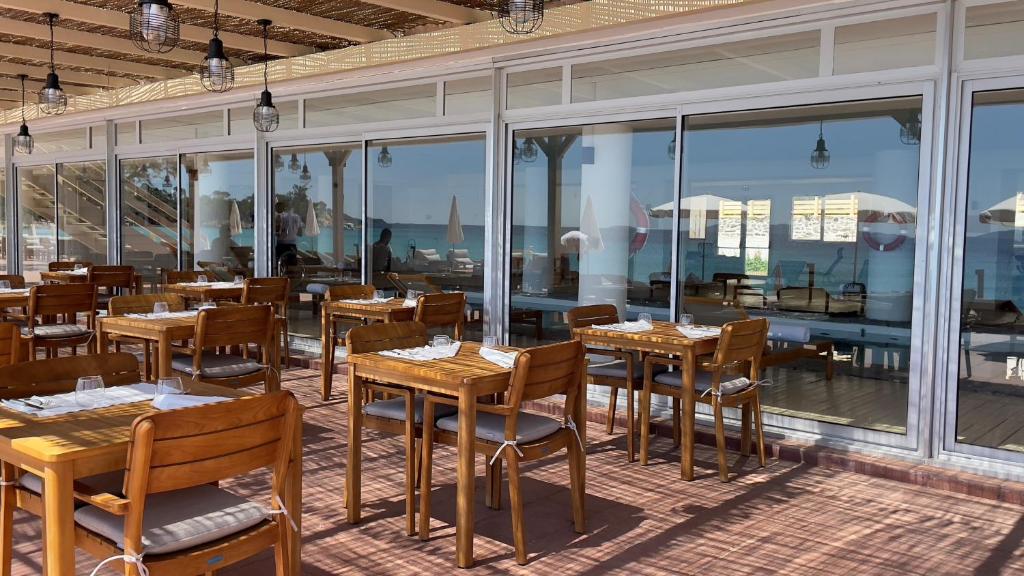 a restaurant with tables and chairs on a patio at Surplage Hotel Cavalière in Le Lavandou