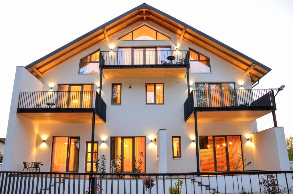 una casa blanca con techo de gambrel en Forest Boutique, en Piteşti