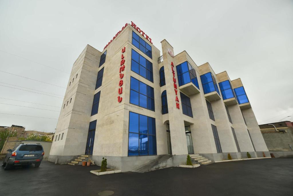 a building with blue windows in a parking lot at Altunyan Hotel in Yerevan