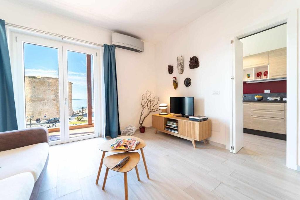een woonkamer met een bank en een tv bij Blue Vibes in Alghero