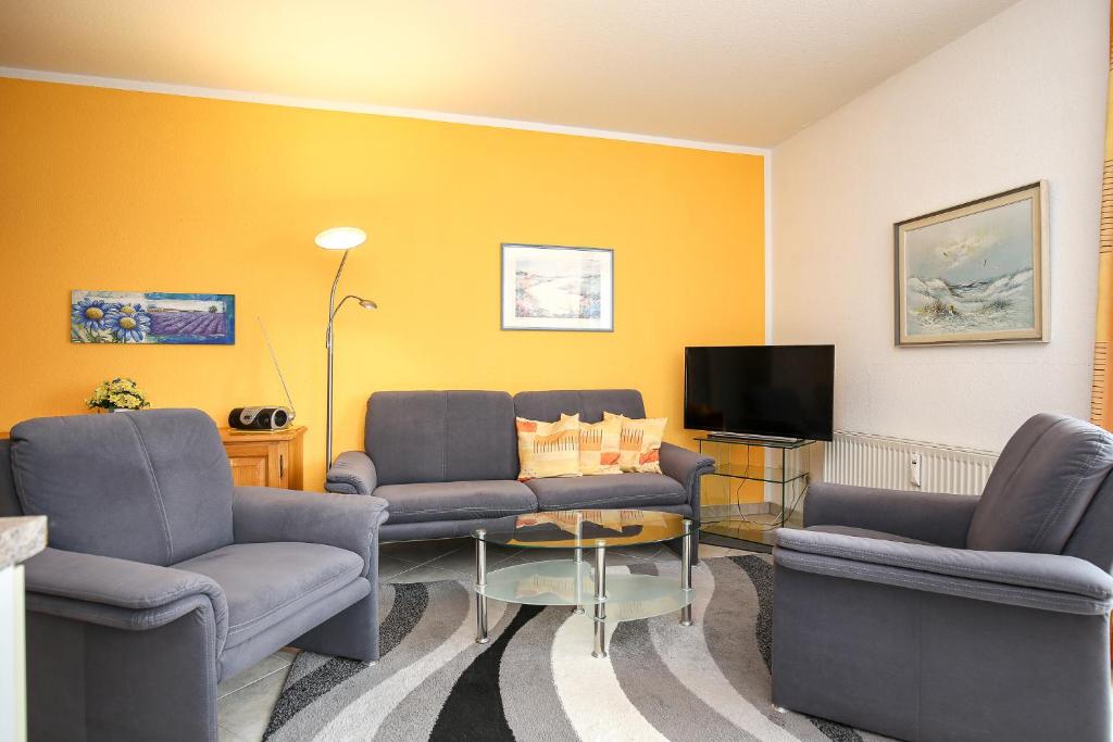 a living room with two couches and a tv at Dünenblick Wohnung 33 in Boltenhagen
