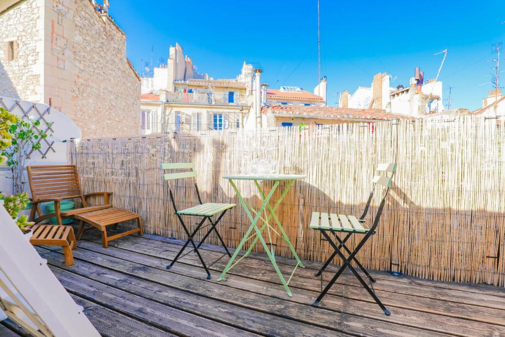 d'une table et de chaises sur un balcon avec une clôture. dans l'établissement Studio avec terrasse - Vieux Port & Cours Julien, à Marseille