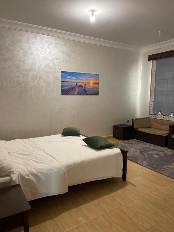 - une chambre avec un lit blanc et un canapé dans l'établissement شاليه على البحر UAE, Abu Dhabi, à Baţīn