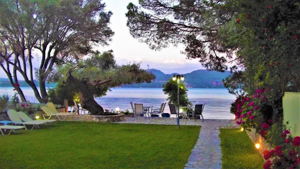 d'une pelouse avec des chaises et une vue sur l'eau. dans l'établissement Zois Apartments, à Nikiana