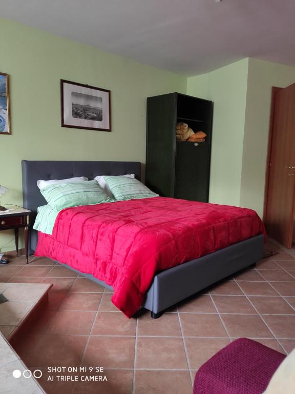 - une chambre avec un lit et une couverture rouge dans l'établissement taverna catena, à Brusciano