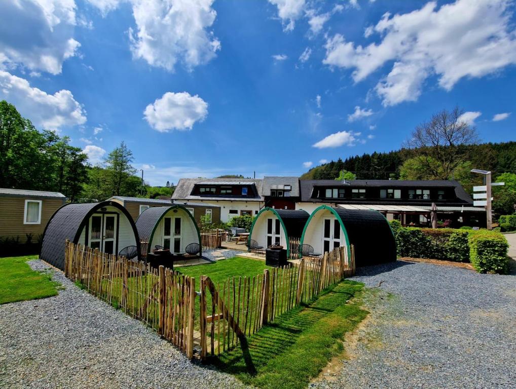 a group of tiny houses in a yard with a fence at Tiny rooms @ camping val d'Or in Enscherange