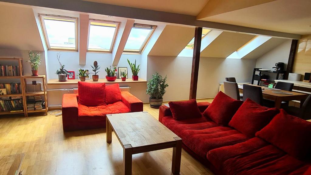 - un salon avec un canapé rouge et une table dans l'établissement 3 BD Spacy Centrum apartment 110m2, à Kaunas