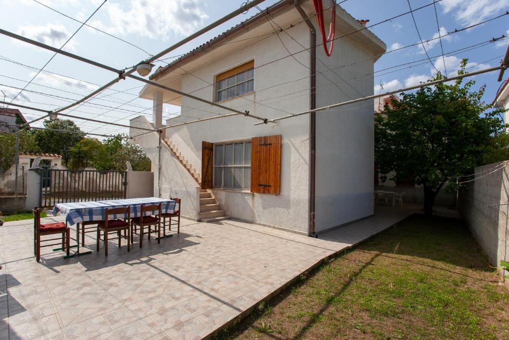 een patio met een tafel en stoelen voor een huis bij Casa con giardino in Posada