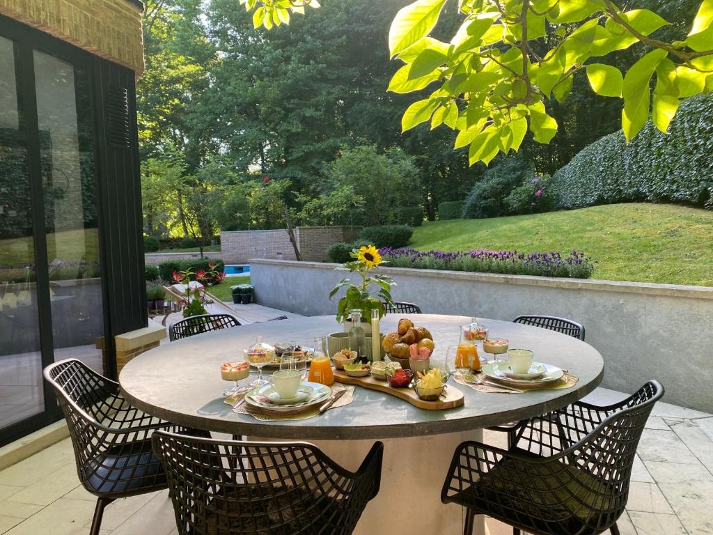 einen Tisch mit Essen auf der Terrasse in der Unterkunft B&B Miranoza in Oud-Heverlee