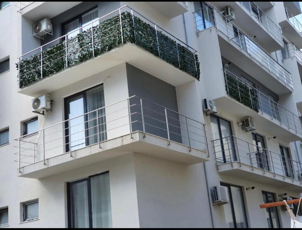 ein weißes Gebäude mit Balkonen und Pflanzen darauf in der Unterkunft First line sea in Năvodari