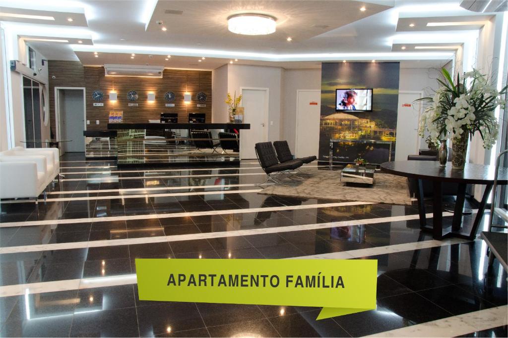 a living room with a tv and a lobby at Bristol Portal do Iguaçu Curitiba Aeroporto in Curitiba