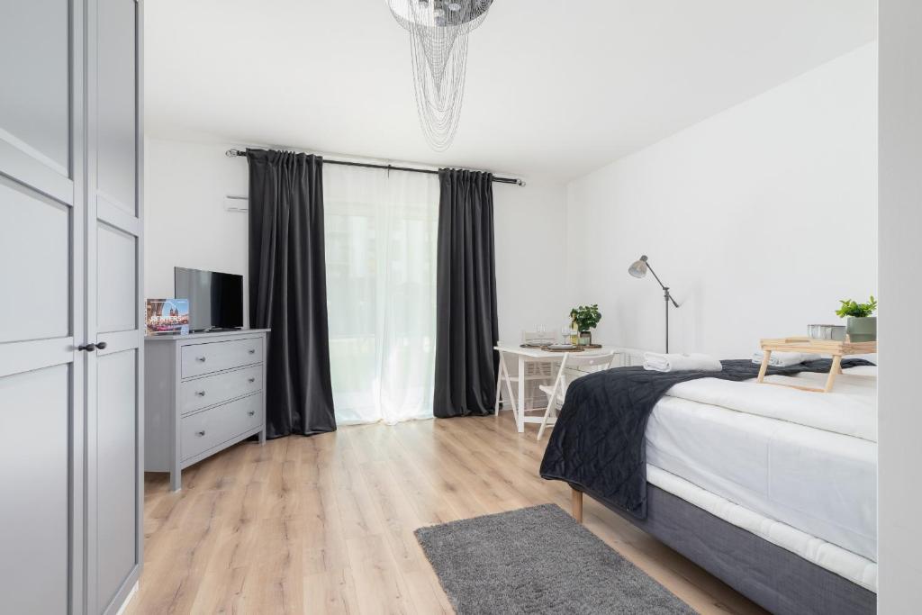 a white bedroom with a bed and a desk at Elegant Pet-Friendly Studio in Krakow by Renters in Krakow