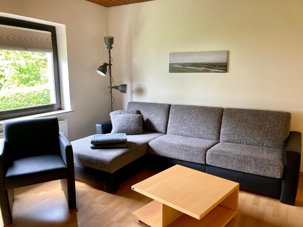 ein Wohnzimmer mit einem Sofa und einem Stuhl in der Unterkunft Haus Wilhelmi Wilhelmi Whg 2 in Wangerooge