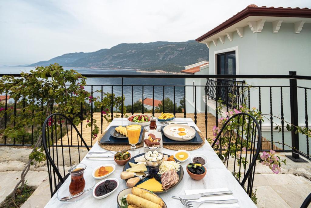 a table with food on top of a balcony at Gümüş Yazar Hotel in Kaş