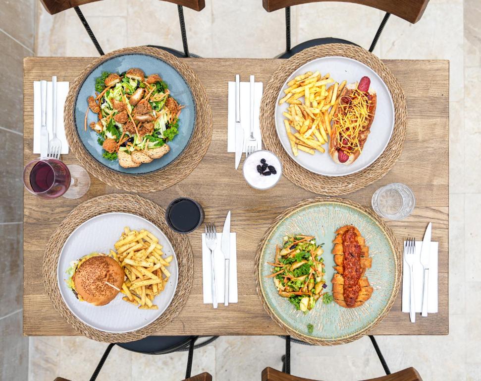 a wooden table with three plates of food on it at Gümüş Yazar Hotel in Kaş