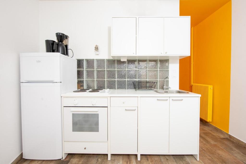 une cuisine avec des armoires blanches et un réfrigérateur blanc dans l'établissement Eden Residence, à Antibes