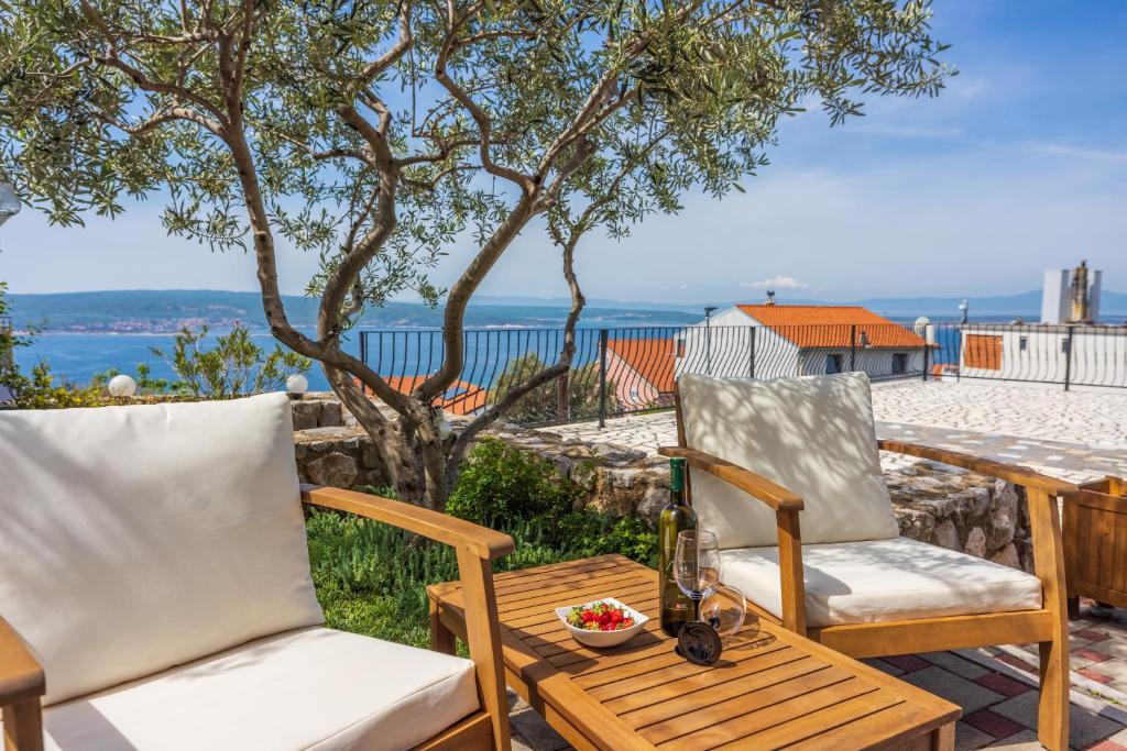 - 2 chaises et une table sur une terrasse donnant sur l'océan dans l'établissement Marie, à Crikvenica