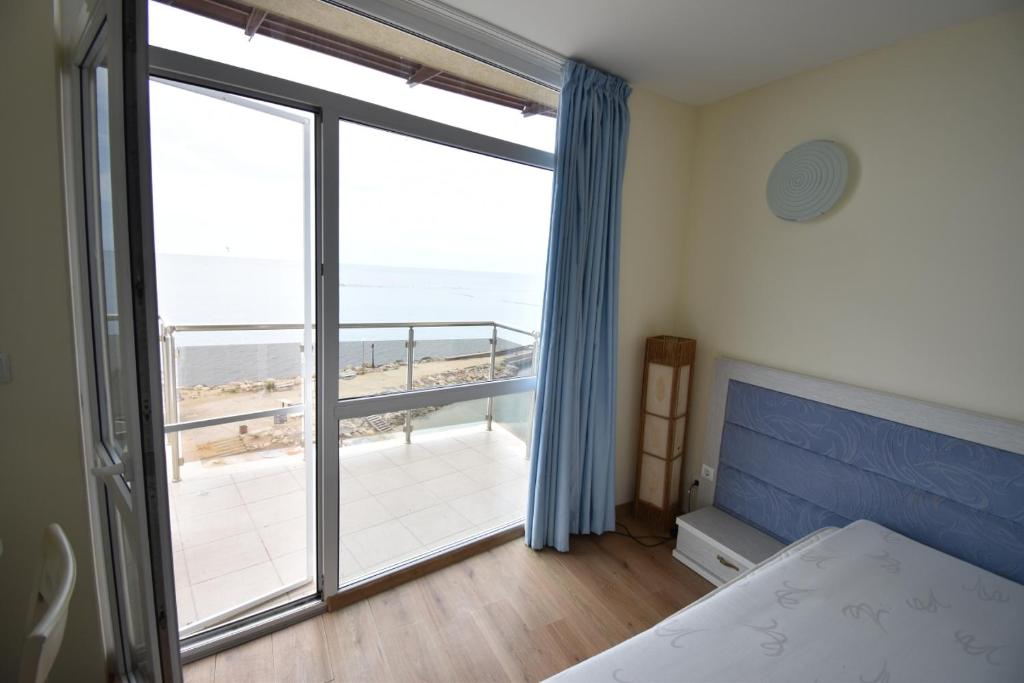 a bedroom with a large window with a view of the ocean at Annabella in Topola