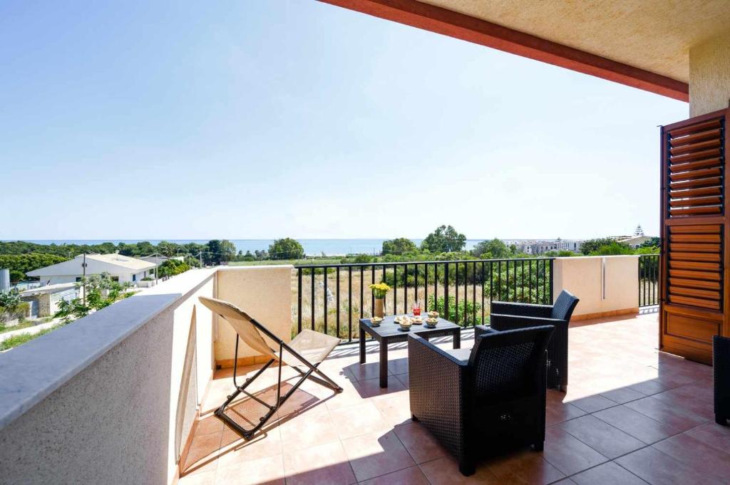 a balcony with a table and chairs on a balcony at Casamici Sampieri Centosicilie in Sampieri