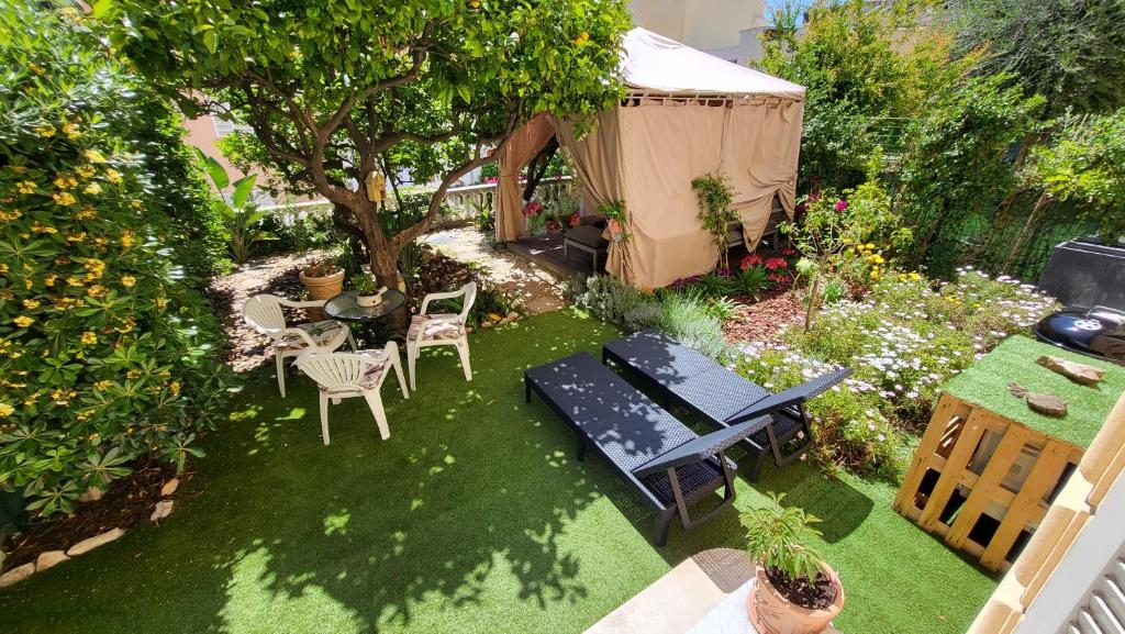 a garden with a table and chairs and a tent at Super Flat, Garden. Bnbrickeys in Monte Carlo