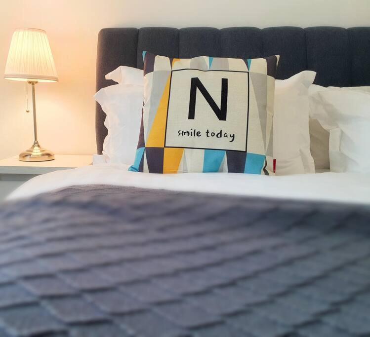 a bed with a pillow with the letter n on it at Arcoris SOHO Mont Kiara in Kuala Lumpur