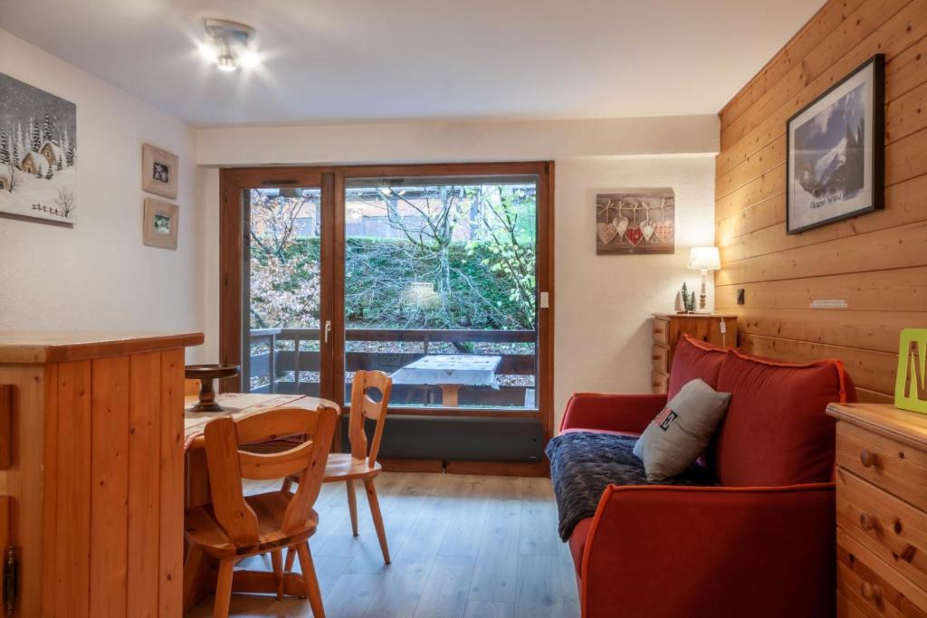 un salon avec un canapé rouge et une table dans l'établissement Corniche B10 - Studio rénové avec coin montagne à 650m des pistes, à Morzine