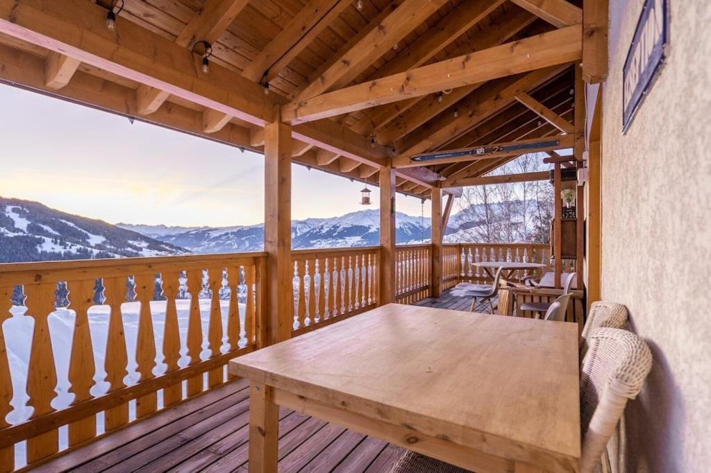- une terrasse couverte en bois avec une table en bois dans l'établissement Ekseption - 7-room chalet + sauna 12/14 persons, à Peisey-Nancroix