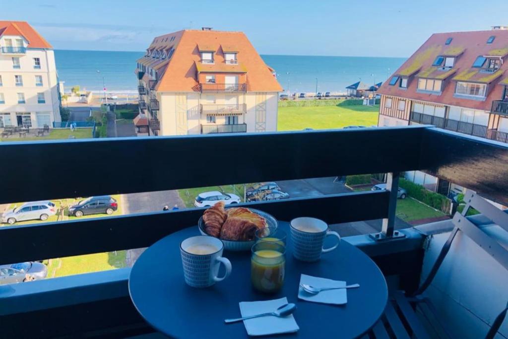 - une table sur un balcon avec vue sur l'océan dans l'établissement Quiet apartment with sea view, à Villers-sur-Mer