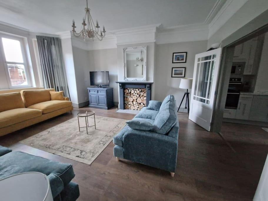 sala de estar con 2 sofás y chimenea en Victorian Beach Villa, Hunstanton Norfolk, en Hunstanton