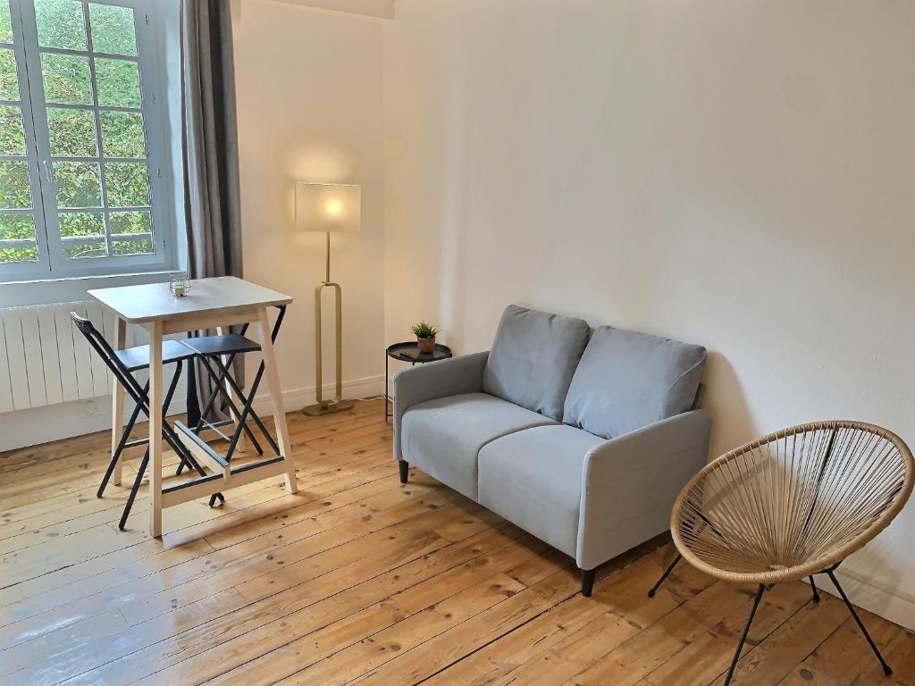 uma sala de estar com um sofá e uma mesa em Vue magique sur le château dans un quartier populaire em Pau