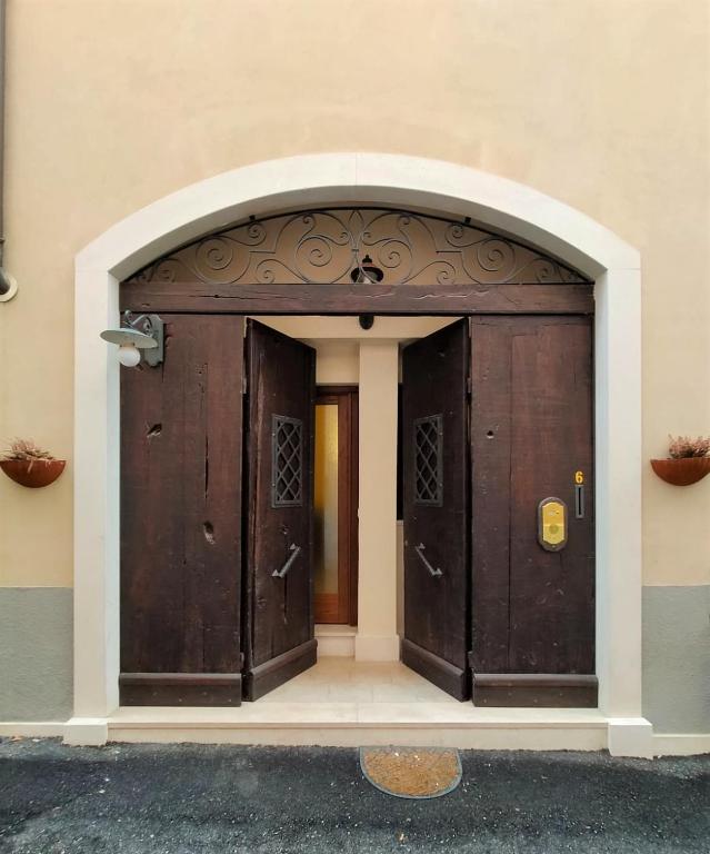 an entrance to a building with two wooden doors at Vittoria House in LʼAquila