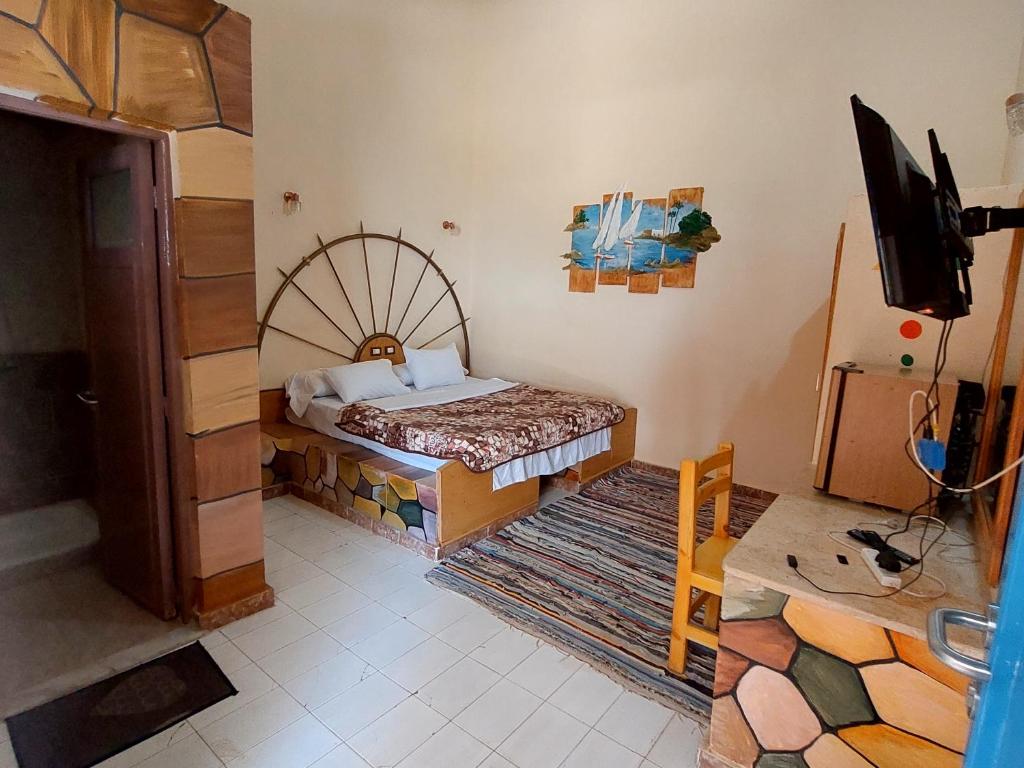 um quarto com uma cama e uma televisão em Hllol Hotel em Abu Simbel