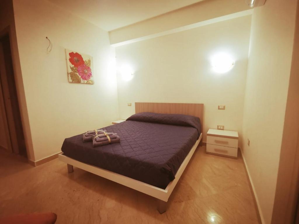 Un dormitorio con una cama con dos zapatos. en KALOS B&B, en Campobello di Licata