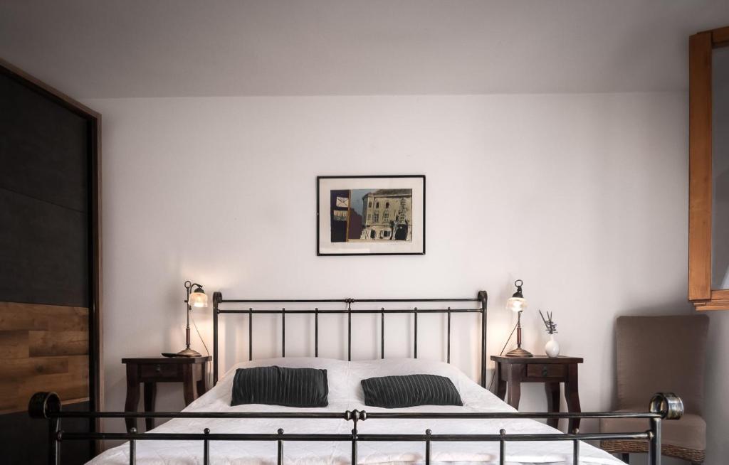 a bedroom with a bed with two night stands and two lamps at Apartman Pergola in Betina