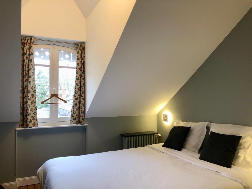een slaapkamer met een wit bed en een raam bij Maison et jardin à Epernay centre ville in Épernay