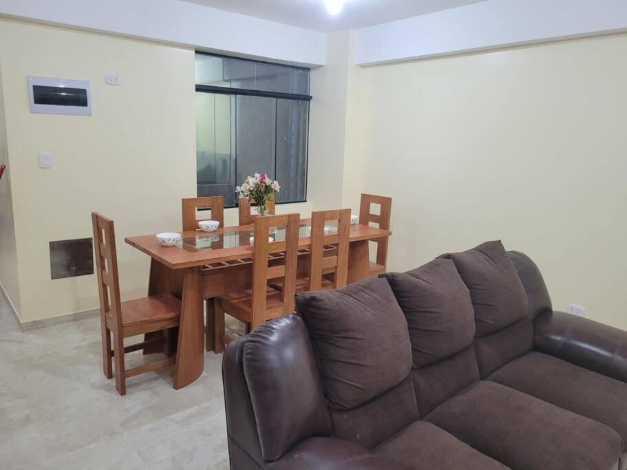 een woonkamer met een bank en een houten tafel bij Apartamento cómodo y tranquilo. Garage gratuito in Cuzco