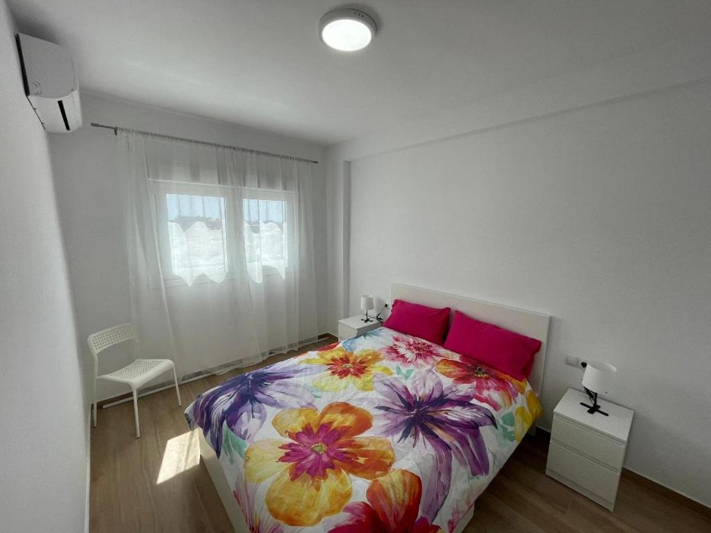 1 dormitorio con 1 cama con colcha de flores en Concordia, en Roquetas de Mar