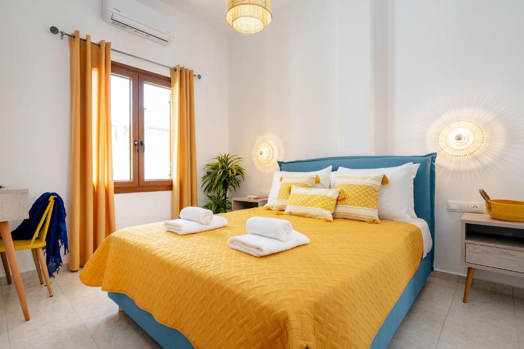 a bedroom with a blue and yellow bed with towels on it at NaxosAir2 in Naxos Chora