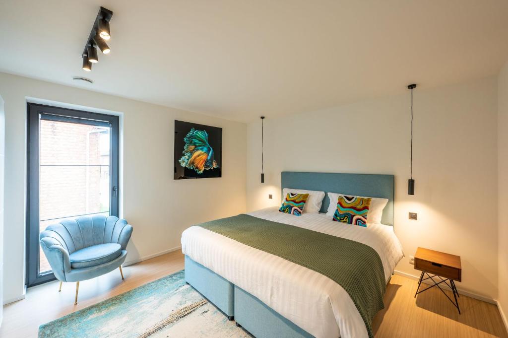 - une chambre avec un lit et une chaise bleue dans l'établissement unique hideaway, holiday house with large garden, à Kortenaken