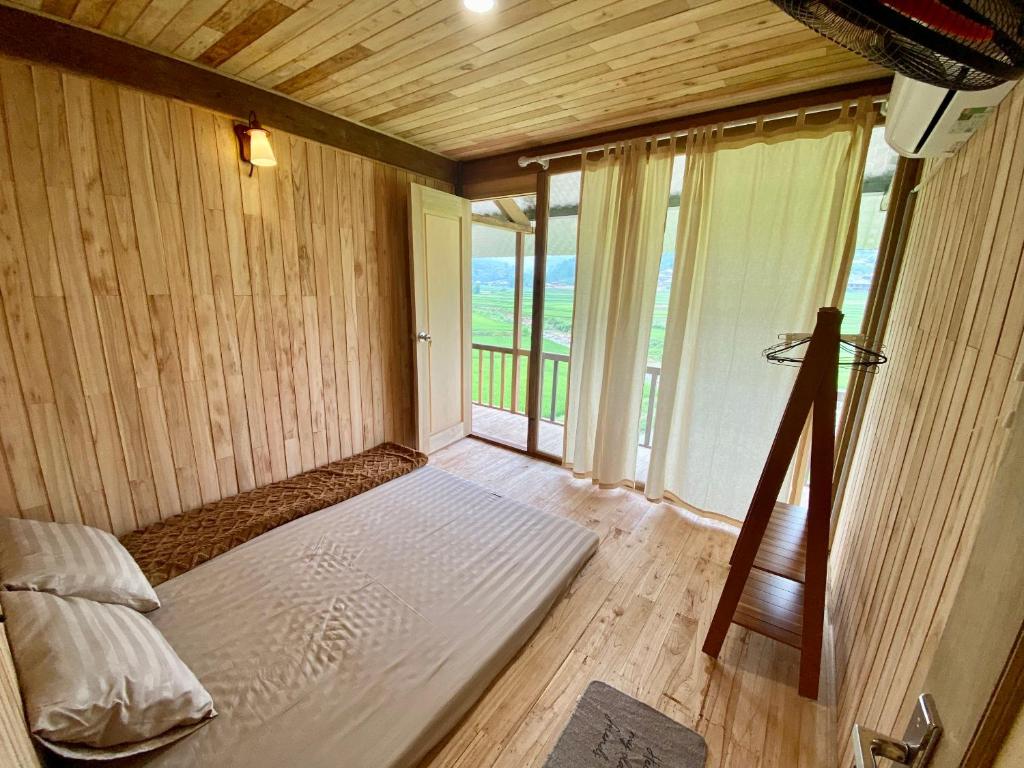 a large room with a bed and a large window at Chipau house Trạm Tấu in Cham Ta Lao