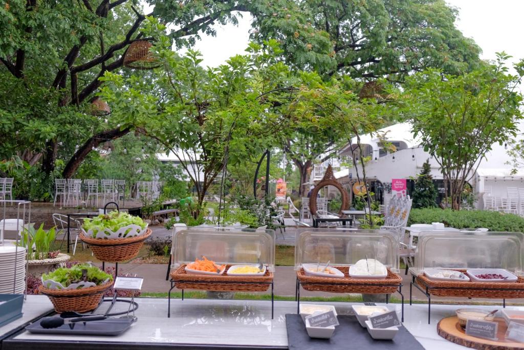 a table with several plates of food on it at Tree Tara hotel in Lampang