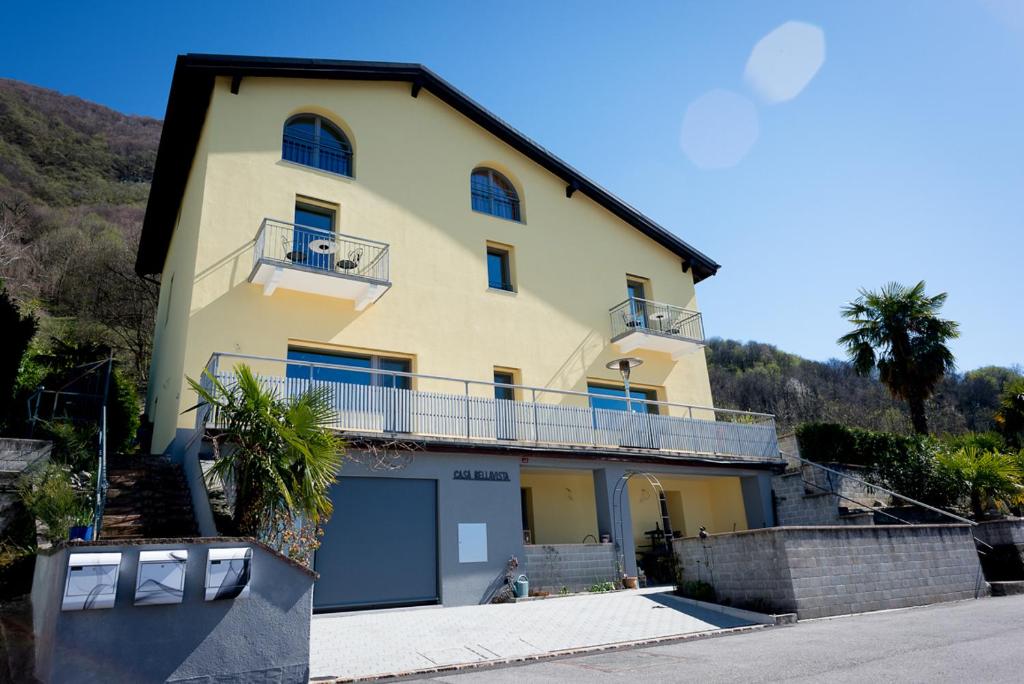 ein gelbes Haus mit einem Balkon und einer Garage in der Unterkunft Casa Bellavista in Pugerna