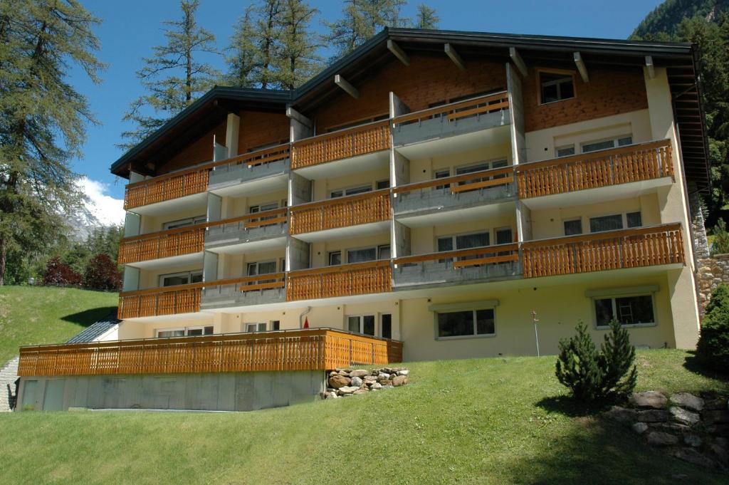 a large apartment building with balconies on a hill at ABA-Sporting Apartment House in Leukerbad