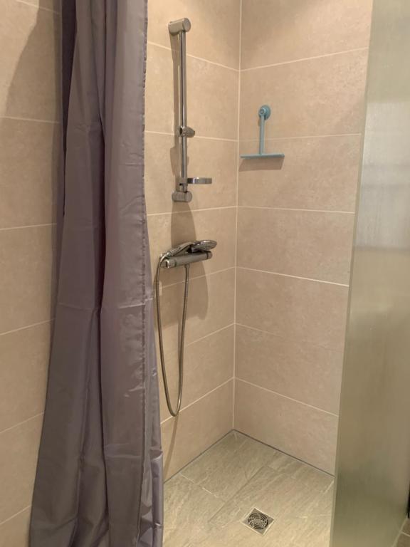 a shower with a shower curtain in a bathroom at Le Café Crème jardin parking in Le Chambon-sur-Lignon