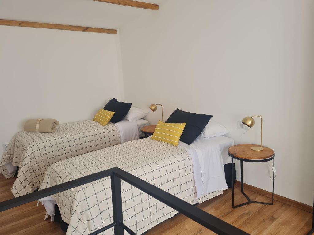 Curuzú CuatiáにあるFactoria - Casa de Huéspedesの黄色と黒の枕が備わるベッド2台が備わる客室です。