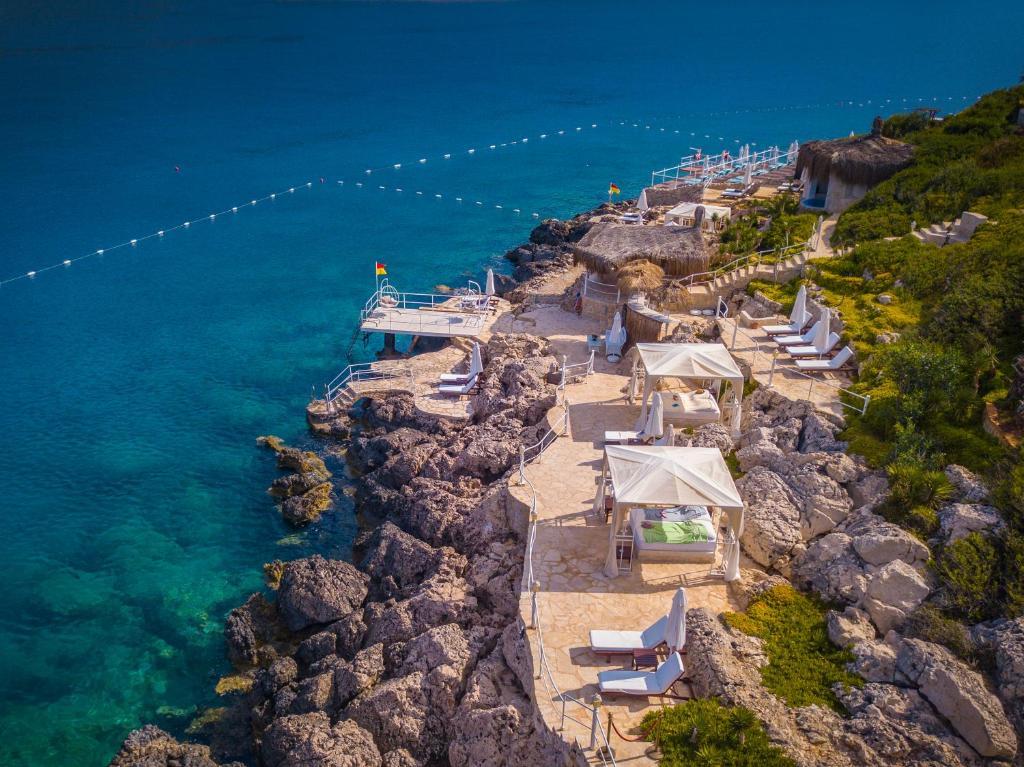 a group of tables and chairs on a rocky shore at Lukka Exclusive Hotel – Adult Only +12 in Kaş